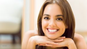 Young Brunette Resting Chin on Interlaced Hands