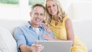 Mature Couple Sitting on Couch With Laptop